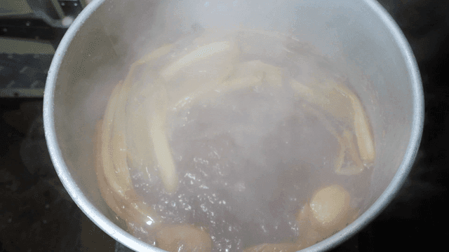 Pot of boiling soy sauce broth with vegetables