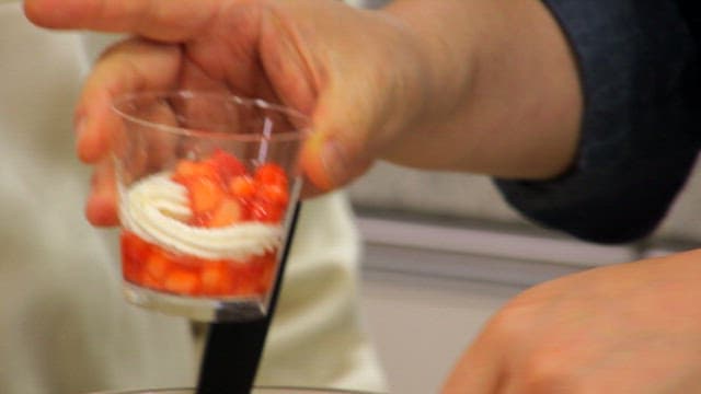 Preparing a strawberry dessert in a cup