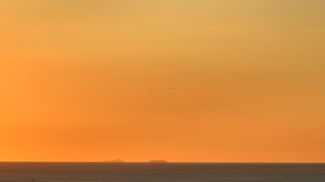 Sunset over the ocean with distant islands