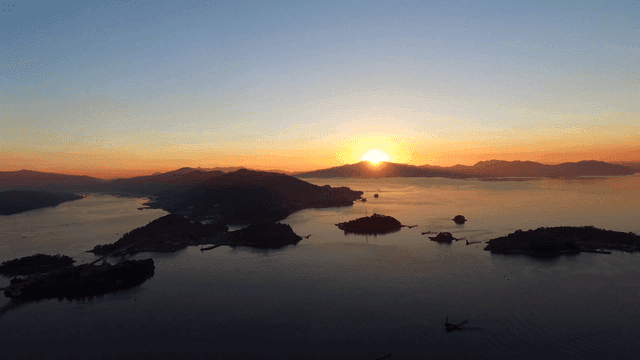 Sunrise over a tranquil sea with islands