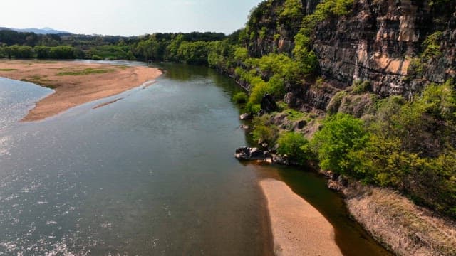 Tranquil river flowing beside rocky cliffs