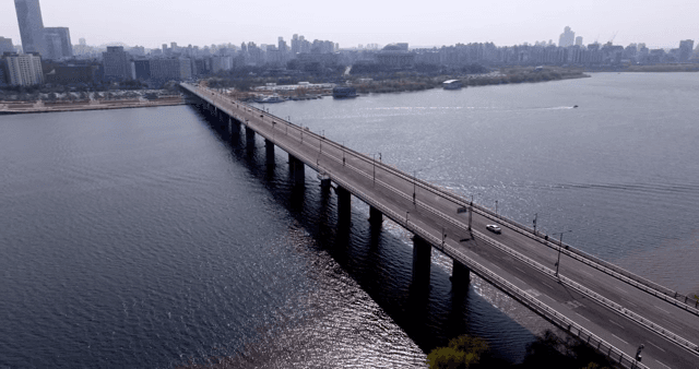 A bridge over a river with city skyline