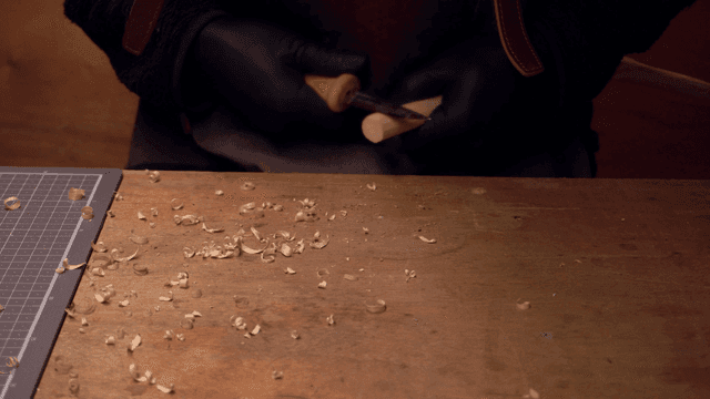 작업대에서 나무를 조각하는 손