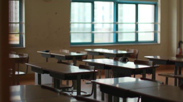 Desk with Open Textbooks in an Empty Classroom