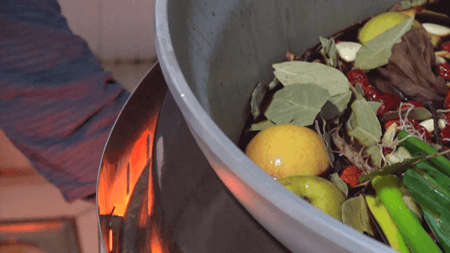 Burner boiling a large pot with various ingredients and soy sauce