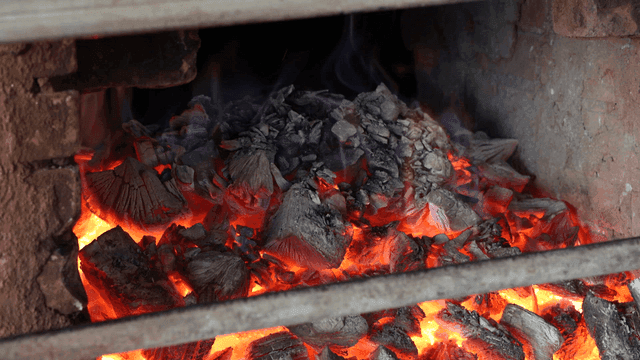 Burning charcoal in a brick oven
