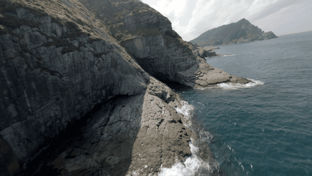 A scenic coastal cliff with lush greenery