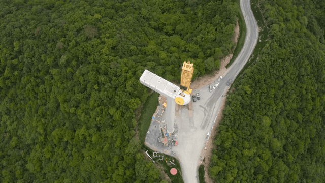 숲 속에서의 크레인을 사용한 풍력 터빈 건설 현장