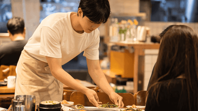 식당에서 한식 반찬을 서빙하는 종업원