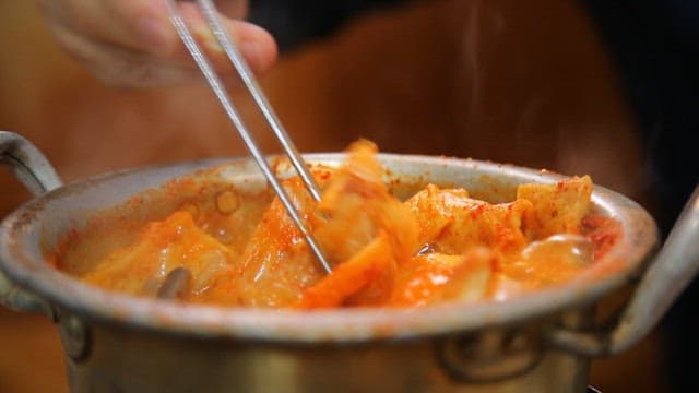 Fish lifted with chopsticks from boiling codfish soup