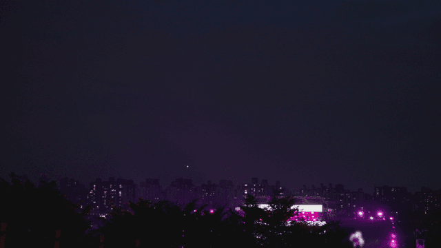 City skyline at night with a vibrant concert view