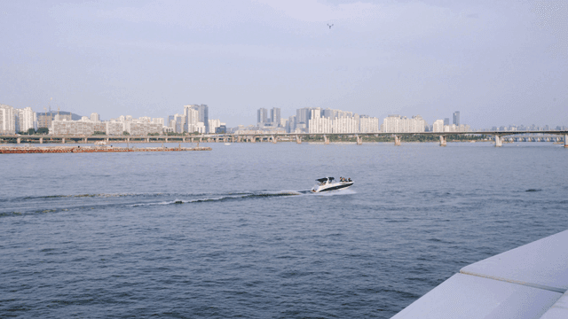 Boat sailing down river with cityscape