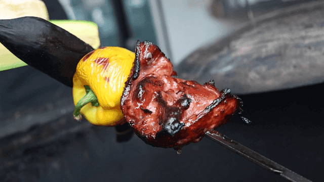 Meat and bell peppers grilled on skewers