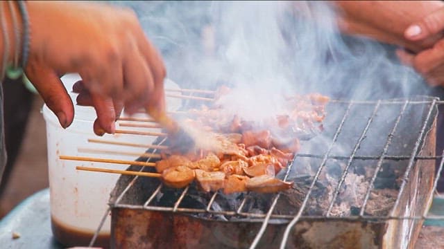 그릴에서 소스를 바른 꼬치를 굽는 모습