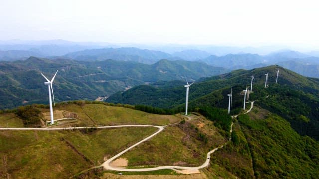 Wind turbines on a lush green mountain range