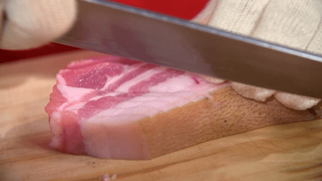 Cutting pork belly on a wooden board