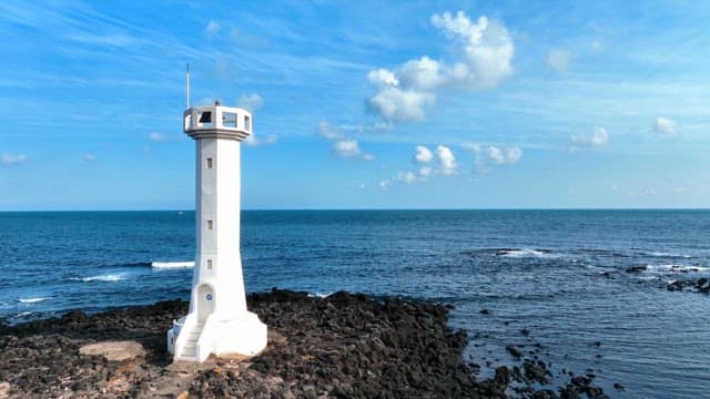 Lighthouse by the rocky seashore