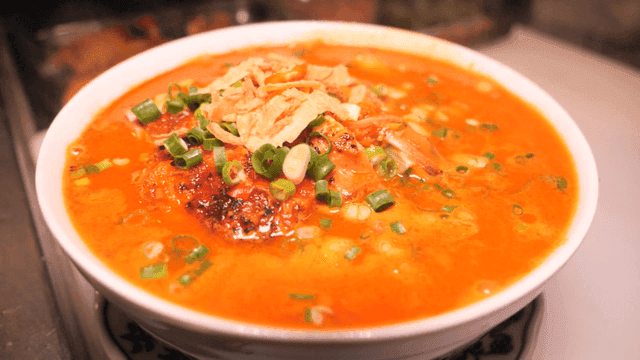 Spicy chicken rice noodles garnished with toppings