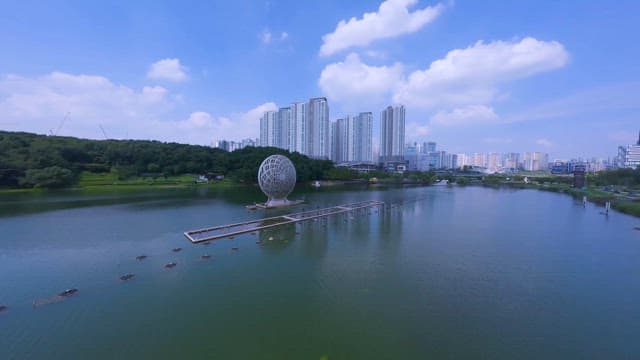 Park with a Sculpture by Waterfront in Midday