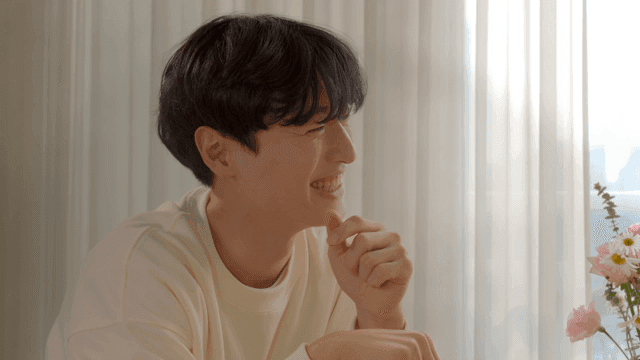 꽃과 함께 창가에서 미소 짓는 남자