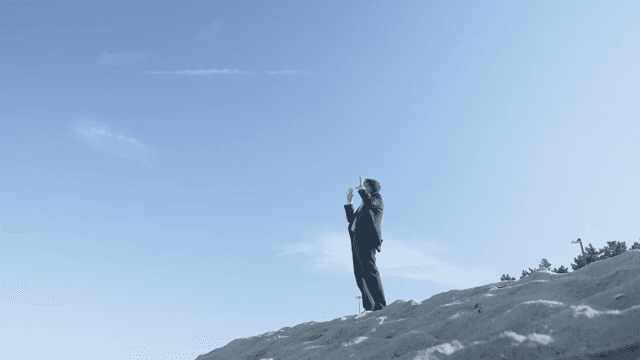 모래 언덕에 서 있는 정장 입은 남자