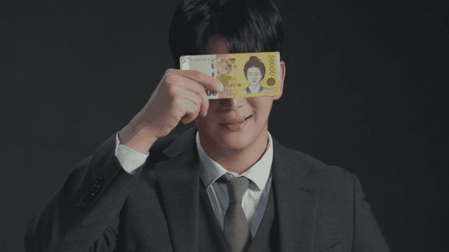 돈으로 눈을 가린 채 웃고 있는 남자