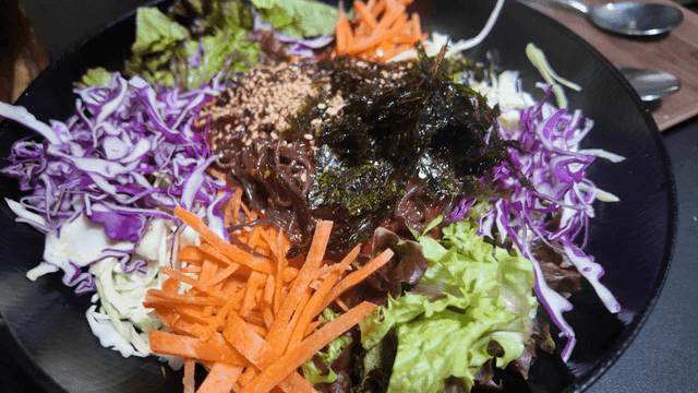 Various vegetable bibim makguksu placed on table