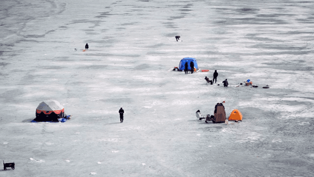 얼어붙은 호수에서 얼음 낚시하는 사람들