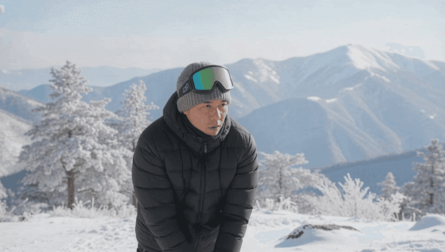 눈 덮인 산에서 스트레칭하는 남성