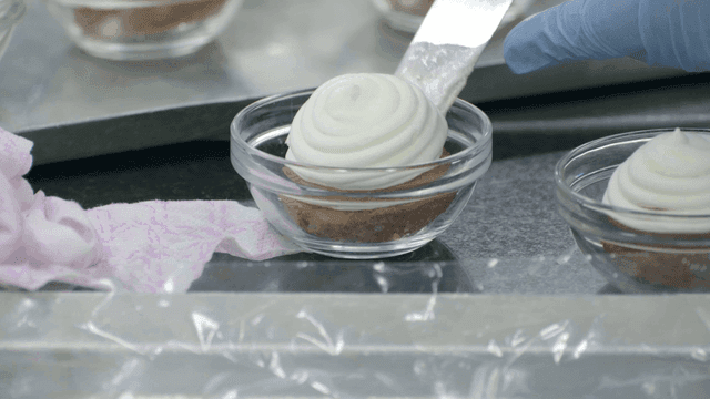 A dessert being prepared in a glass bowl