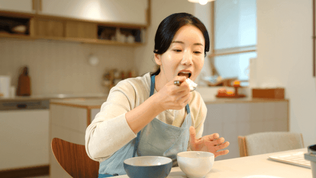 Woman eating white rice in cozy kitchen