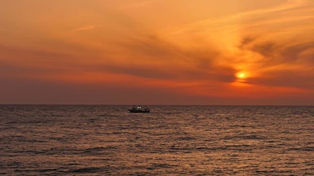 Serene sunset over the ocean with a boat