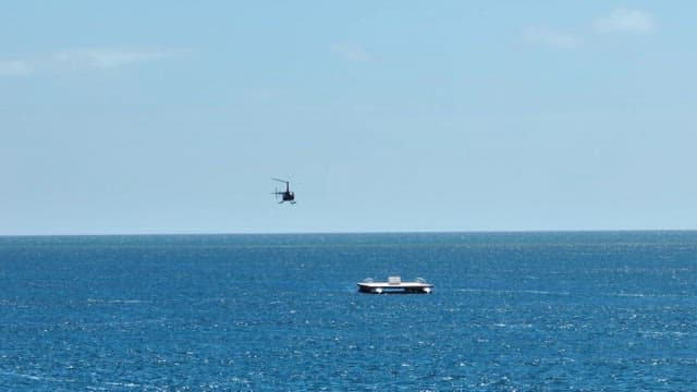 Helicopter flying over the ocean