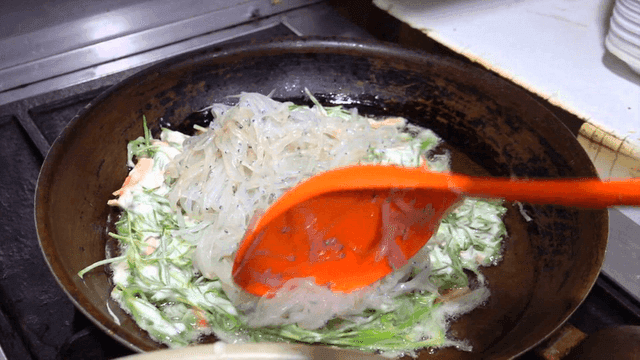 Sizzling ice fish pancake in oiled frying pan