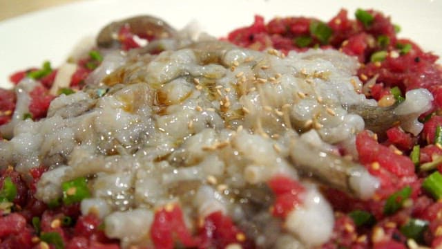 참깨를 곁들인 신선한 낙지 육회 탕탕이 요리