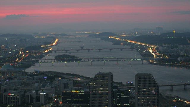 Twilight Cityscape with Illuminated Bridge and River