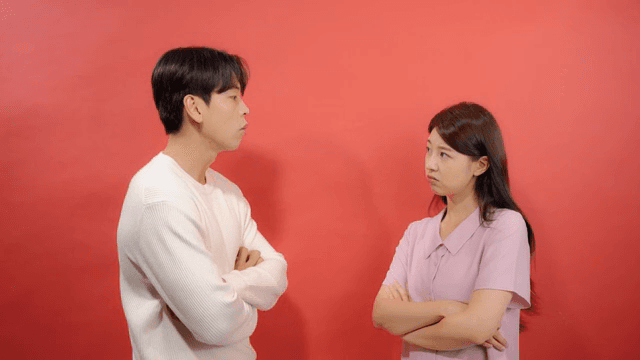 팔짱을 낀 채 서로를 노려보는 두 남녀