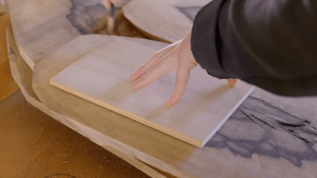 나무 판자를 측정하고 표시하는 손