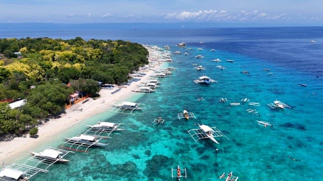 Tropical beach with boats and clear water