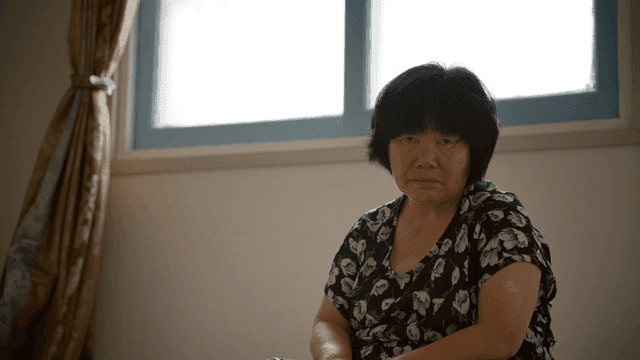 An elderly woman sitting indoors