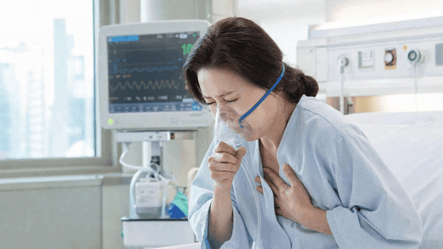 Female patient in hospital room wearing oxygen mask