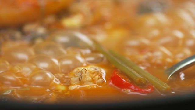 Spoonful of boiling hot spicy fish stew