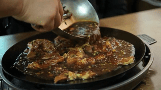 양념된 갈비가 뜨거운 팬에서 요리되는 장면