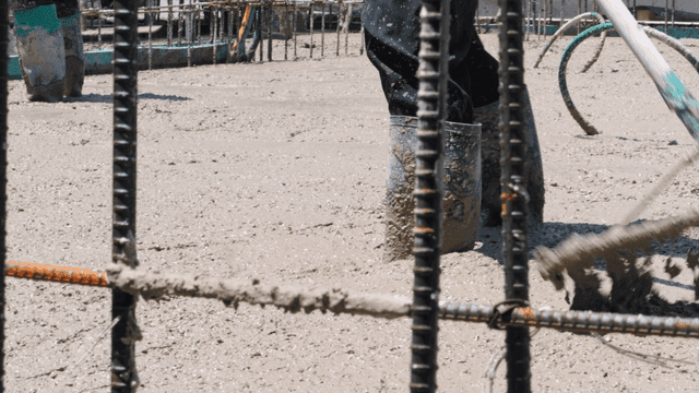 Worker smoothing wet concrete on a site