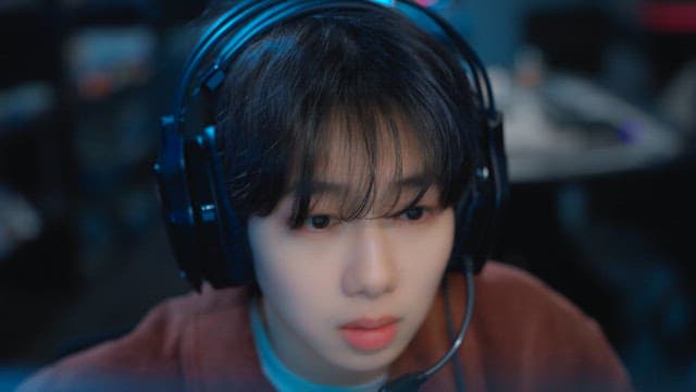 스크린에 집중하며 헤드셋을 끼는 게이머