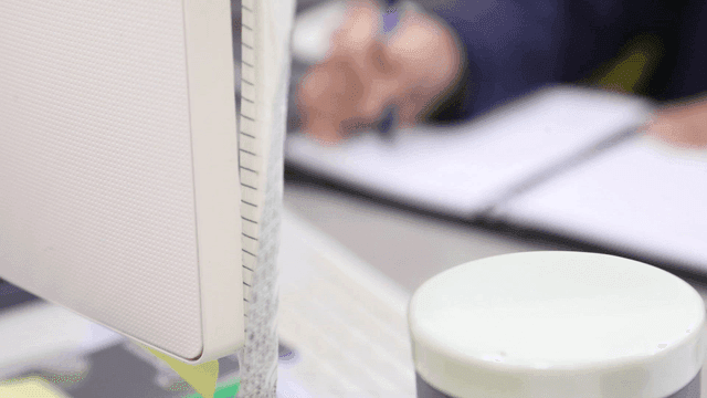 책상에서 메모를 하는 사람