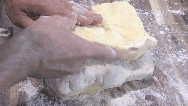 밀가루를 뿌린 조리대에서 반죽을 쌓는 제빵사 손