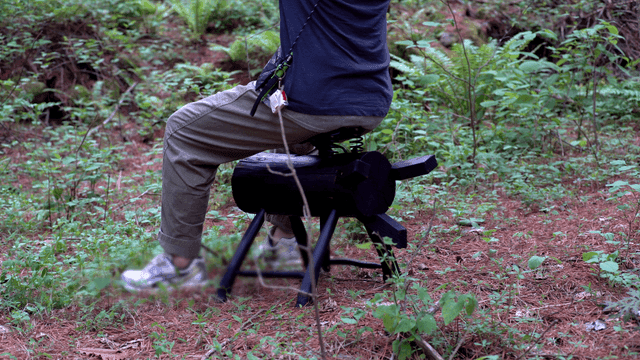 숲속에서 통나무에 앉아 있는 사람