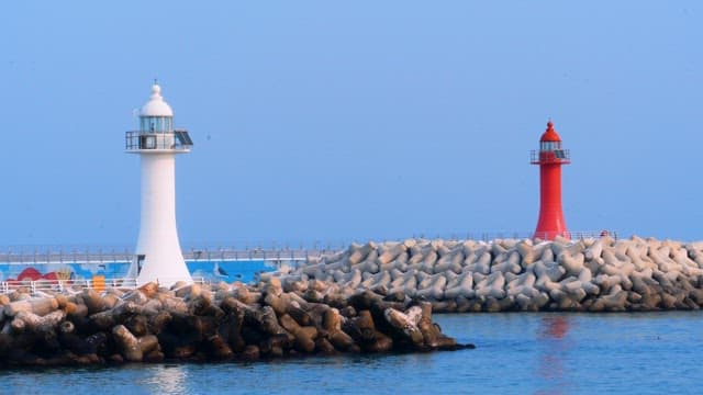 Two lighthouses on a breakwater during a calm day