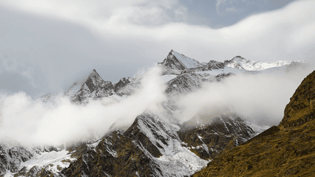 Snowy mountain peaks with clouds
